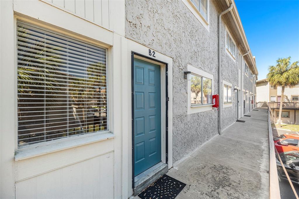 An exterior view of a multi-story apartment building with a blue door labeled B2 — 6311 NEWTOWN CIRCLE UNIT 11B2, TAMPA, FL
