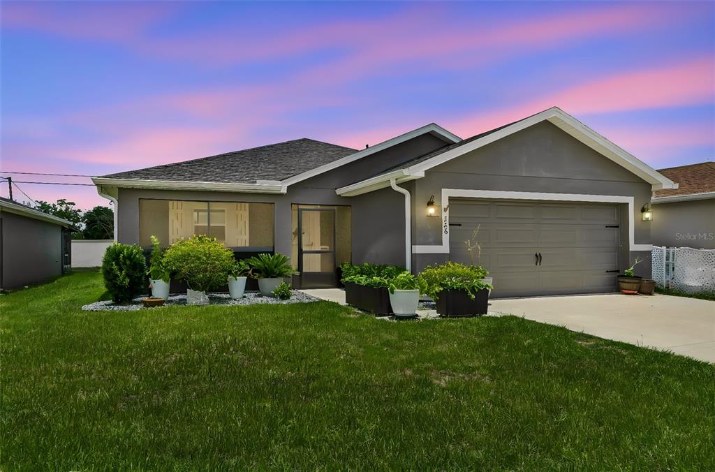 A gray single-story house with a two-car garage and a screened-in front entryway — 236 FOXTAIL LOOP, DAVENPORT, FL