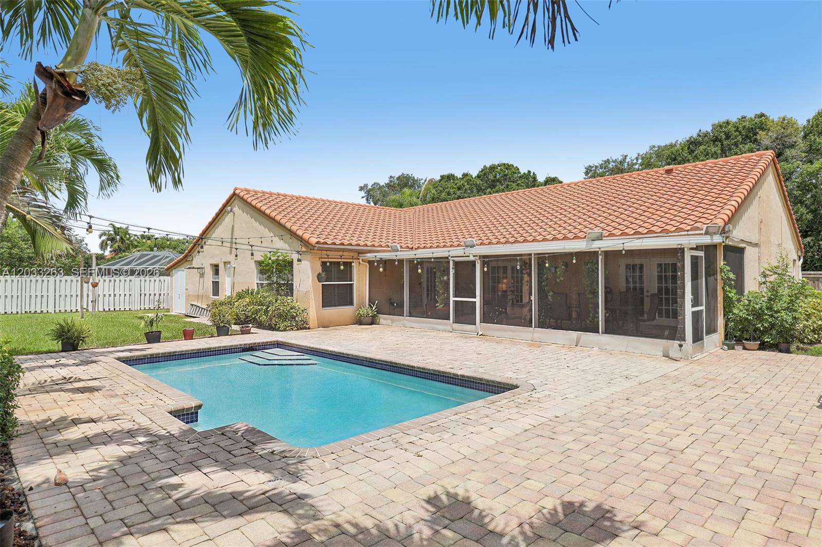 A backyard features a rectangular swimming pool, a paved patio, and a screened-in porch area — 13100 NW 11th Dr, Sunrise FL 33323, SUNRISE, FL