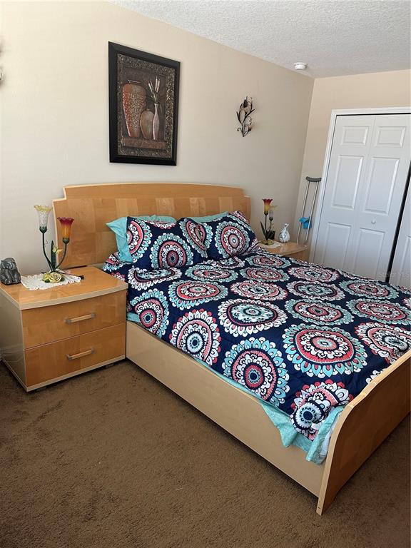 A bedroom features a light wood bed frame, a matching nightstand, and patterned bedding — 4858 TERRA SOLE PLACE, ST CLOUD, FL