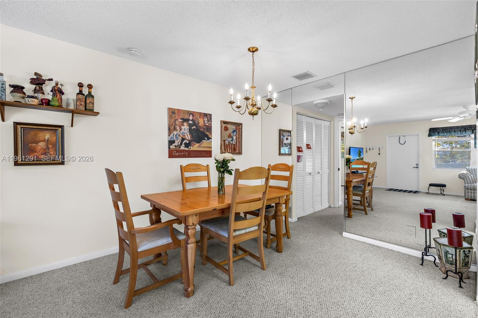 A dining room features a wooden table, four chairs, a chandelier, and a mirrored wall — 316 Tilford O # 316, Deerfield Beach FL 33442, DEERFIELD BEACH, FL