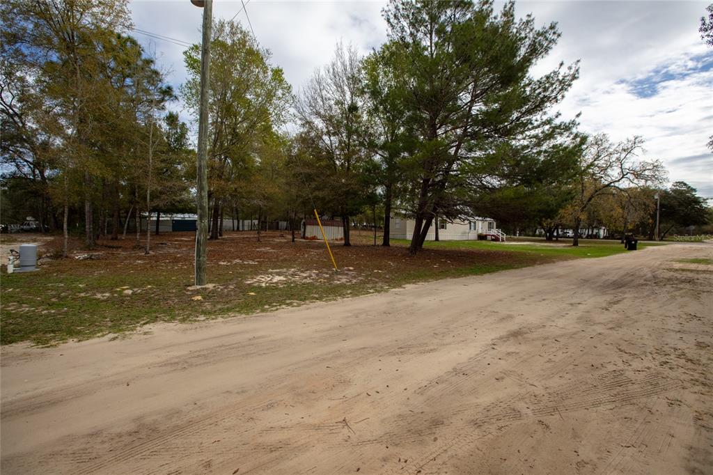 A dirt road runs alongside a wooded, undeveloped lot with a small shed — 7160 PURDUE STREET, KEYSTONE HEIGHTS, FL