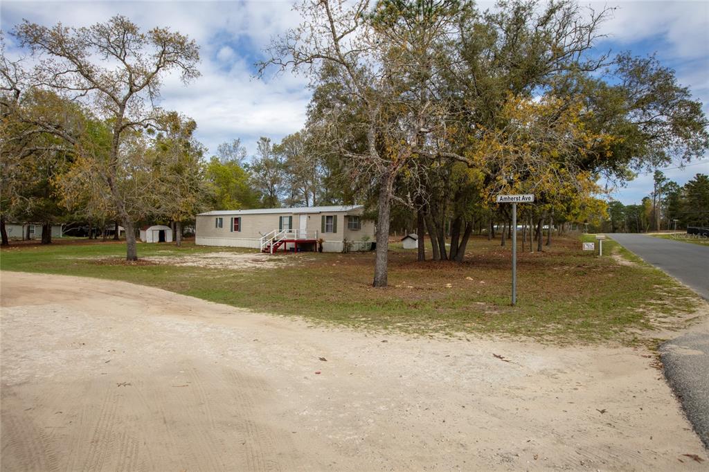 A single-story mobile home sits on a grassy lot near a street sign — 7160 PURDUE STREET, KEYSTONE HEIGHTS, FL