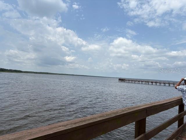 A wooden pier extends into a large lake under a partly cloudy blue sky — 213 PLUMOSA DRIVE, INDIAN LAKE ESTATES, FL