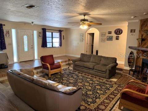 A living room features a grey sofa, a red armchair, and a patterned area rug — 30 PLACID OAKS DRIVE, LAKE PLACID, FL