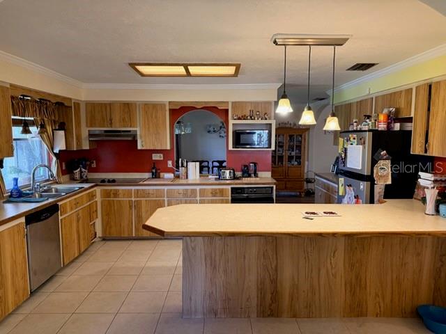 A kitchen features light wood cabinets, a large island, and a red accent wall — 30 PLACID OAKS DRIVE, LAKE PLACID, FL