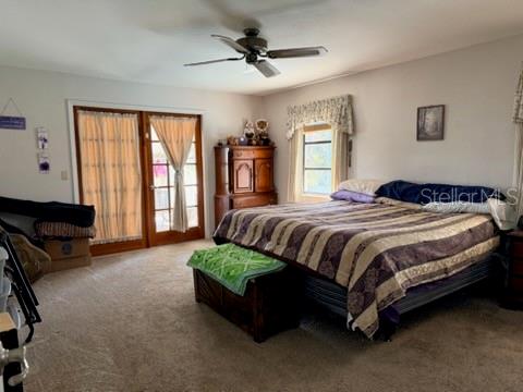 A bedroom features a large bed, a wooden armoire, and sliding glass doors with curtains — 30 PLACID OAKS DRIVE, LAKE PLACID, FL