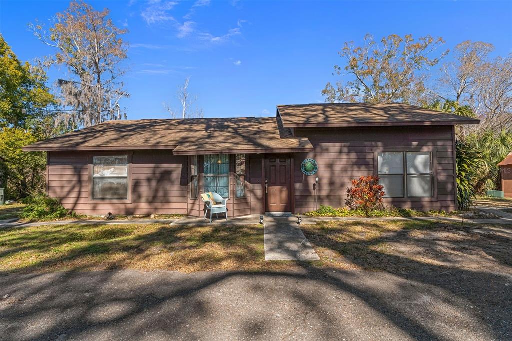 A single-story brown house with a shingled roof, a front walkway, and a bay window — 8301 CONGRESS STREET, PORT RICHEY, FL