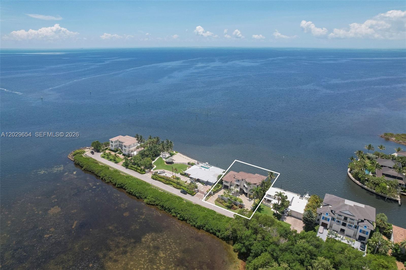An aerial view shows a waterfront house highlighted by a white outline on a peninsula — 750 Lugo Ave, Coral Gables FL 33156, CORAL GABLES, FL