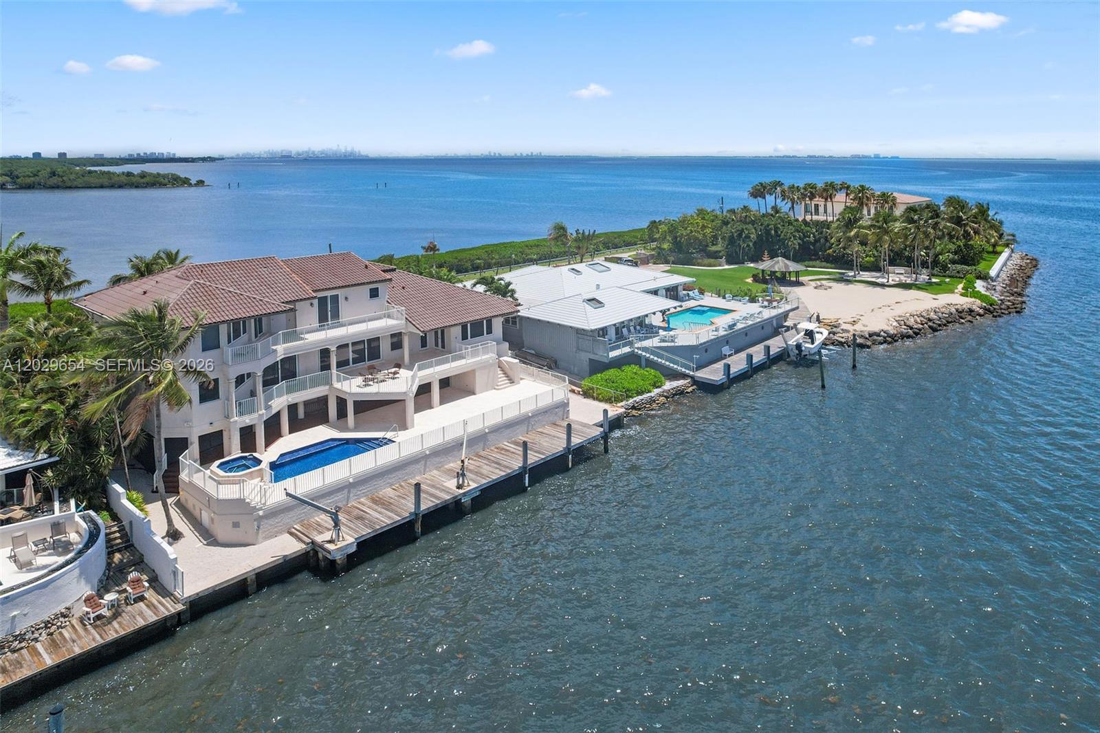An aerial view shows two waterfront houses with pools, docks, and a sandy beach area — 750 Lugo Ave, Coral Gables FL 33156, CORAL GABLES, FL
