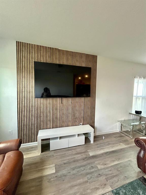 A living room features a wall with vertical wood slats, a television, and a white console — 805 ORCHID GROVE BOULEVARD, DAVENPORT, FL