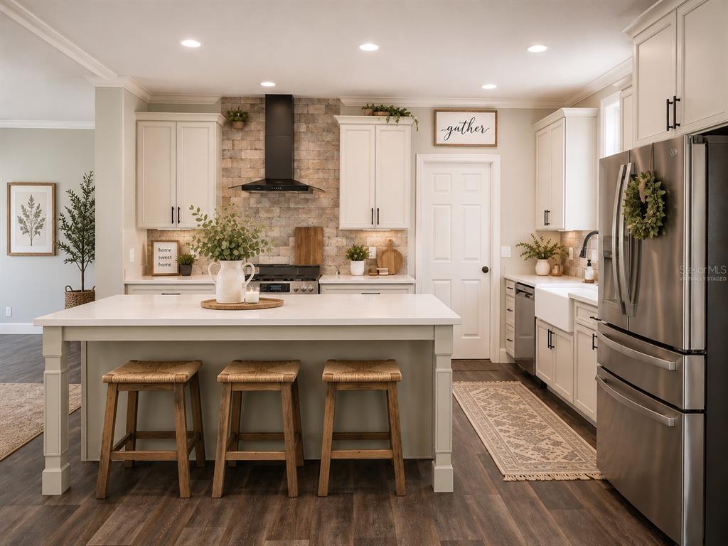 A kitchen features white cabinetry, a stone backsplash, a central island with stools, and stainless appliances — 11160 NW 5TH AVENUE, BRANFORD, FL