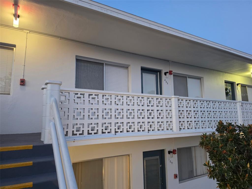 An exterior view of a two-story apartment building with a decorative white concrete block railing — 8221 112TH STREET UNIT 209, SEMINOLE, FL