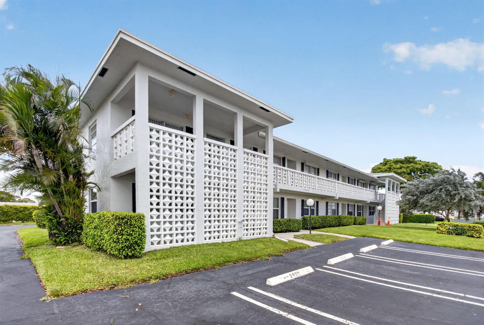 A two-story apartment building with a white decorative concrete block screen and parking lot — 2401 Del Aire Boulevard # 101, Delray Beach FL 33445, DELRAY BEACH, FL