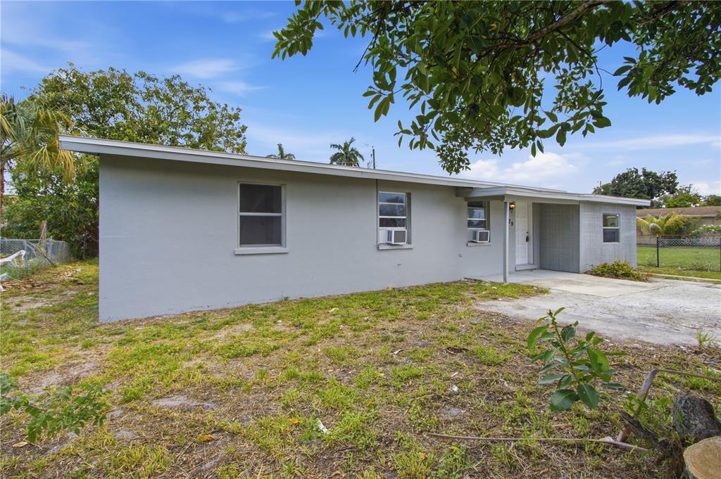 A single-story gray house with a flat roof and a concrete driveway — 1629 PAWNEE STREET, FORT MYERS, FL