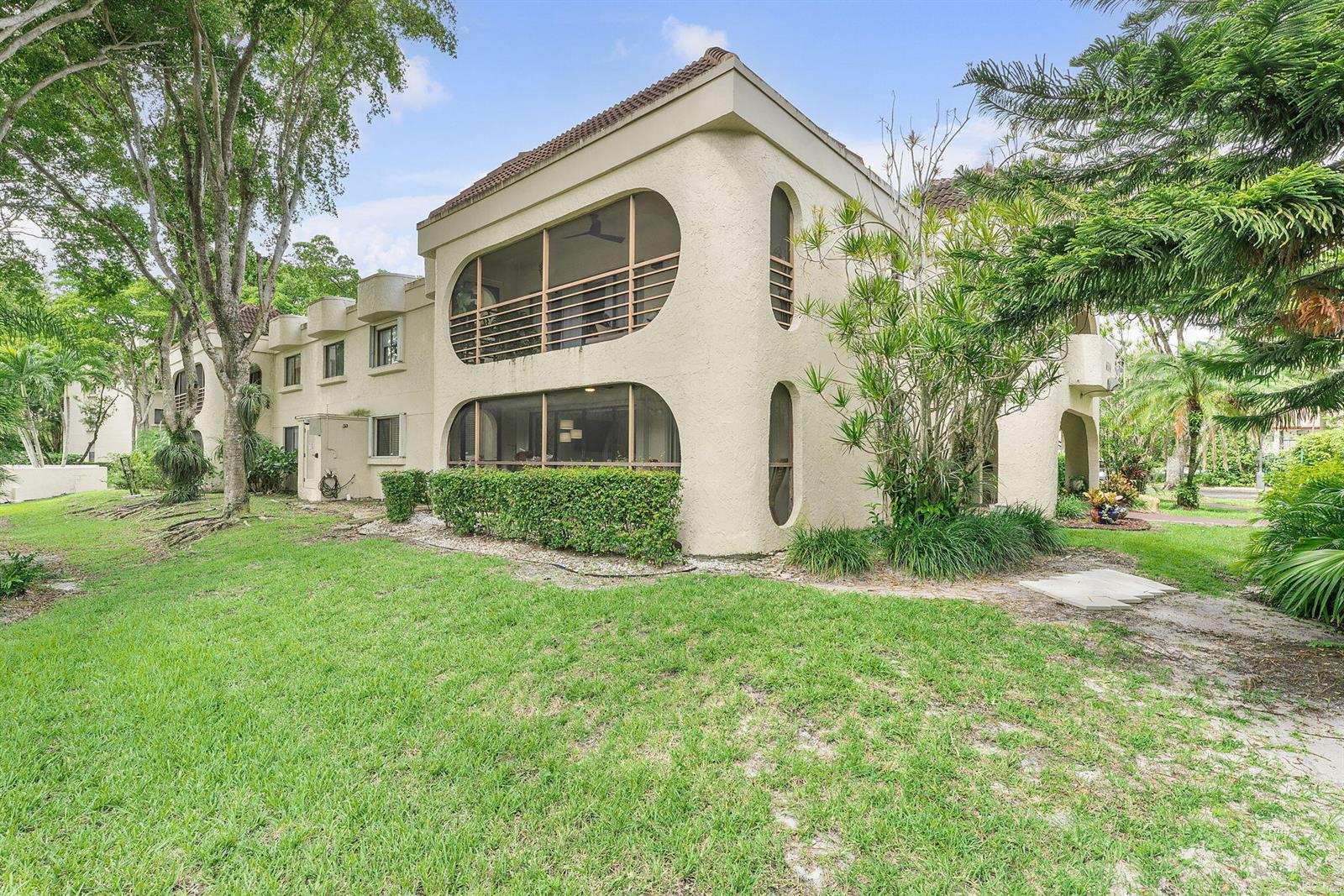 A kitchen features white cabinets, stainless steel appliances, a patterned tile backsplash, and light countertops — 6314 Longboat Lane W, Boca Raton FL 33433, BOCA RATON, FL