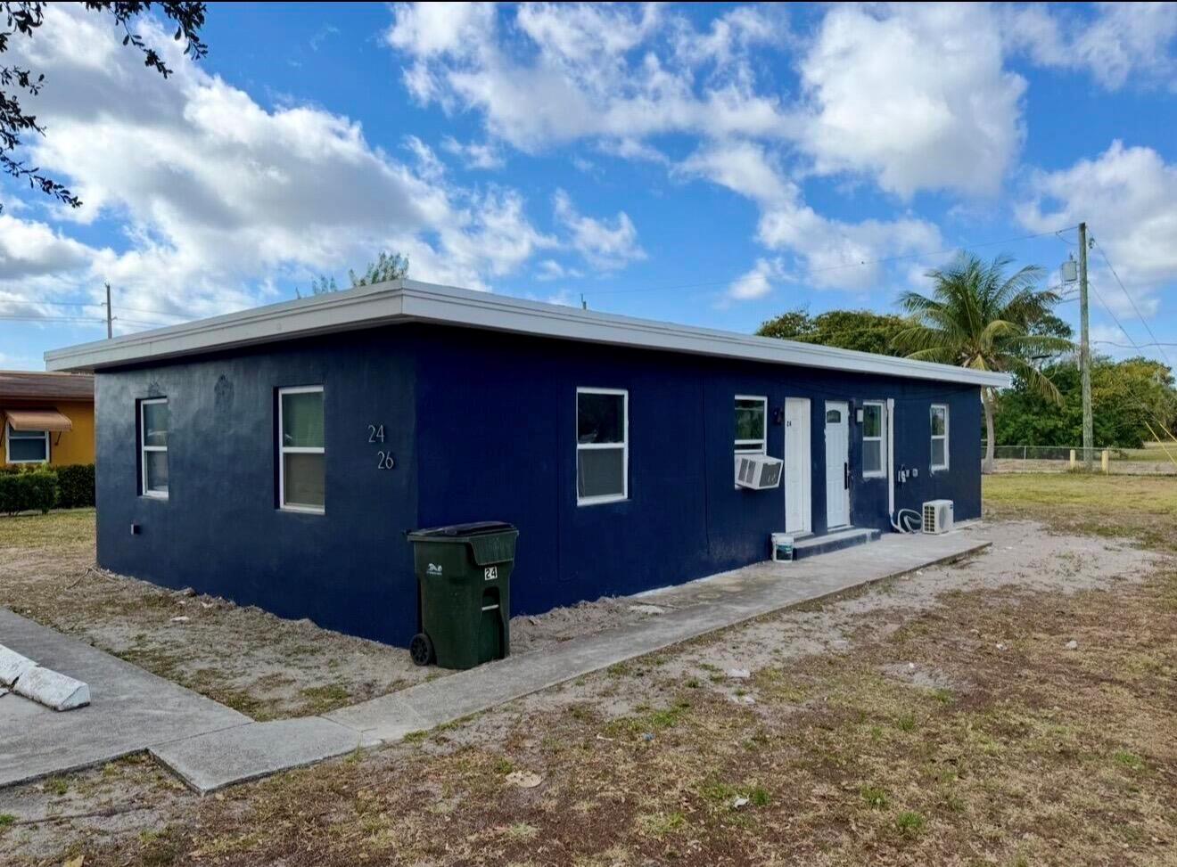 A single-story blue duplex building with a flat roof and a concrete walkway — 24 SW 10th Avenue, Delray Beach FL 33444, DELRAY BEACH, FL