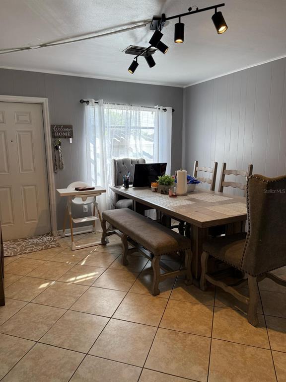 A dining room features a wooden table, a bench, upholstered chairs, and track lighting — 311 CONGRESS AVENUE, AUBURNDALE, FL