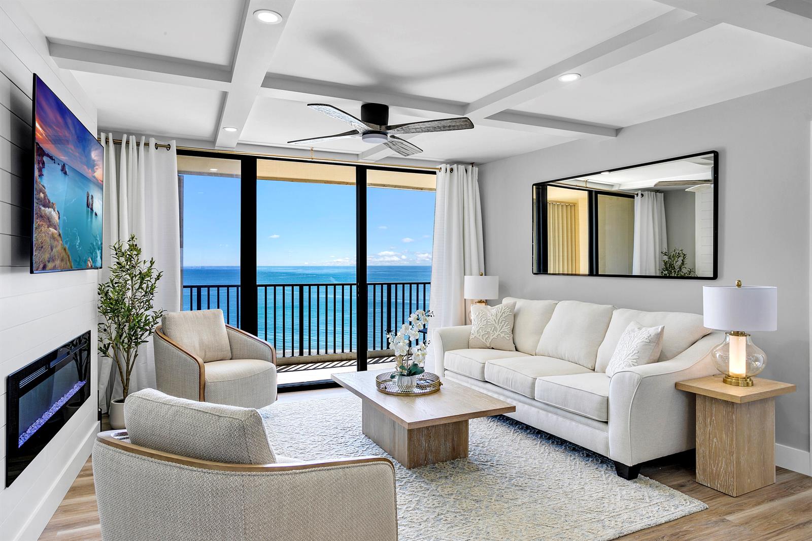 A bright living room features a white sofa, armchairs, fireplace, and a balcony overlooking ocean — 300 Ocean Trail Way # 908, Jupiter FL 33477, JUPITER, FL