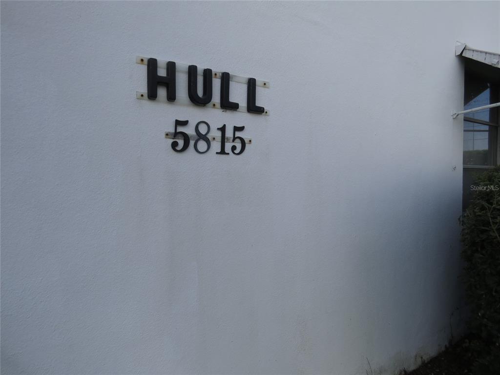 The exterior white wall features black lettering reading HULL and the number 5815 — 5815 18TH STREET N UNIT 16, ST PETERSBURG, FL