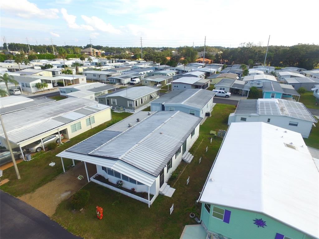 An aerial view of a mobile home park featuring several manufactured homes with metal roofs — 37832 MADEIRA AVENUE, ZEPHYRHILLS, FL