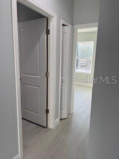 An interior view from an entryway looking toward a kitchen with light wood-look flooring — 17174 NIXON AVENUE, PORT CHARLOTTE, FL