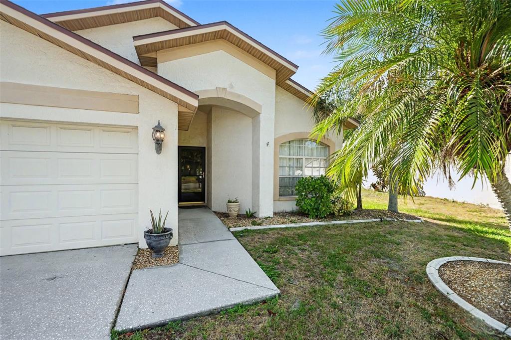 A single-story house exterior features a white garage, a front entryway, and a palm tree — 1714 LARABIE COURT, BRANDON, FL