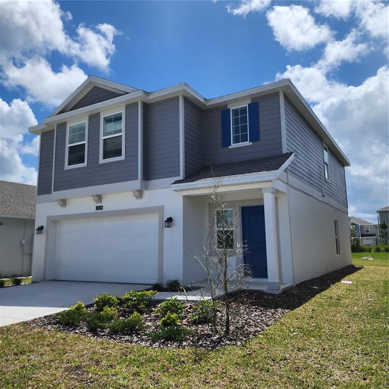 A two-story house with a white stucco lower level, gray siding upper level, and blue door — 5838 LE MARIN WAY, KISSIMMEE, FL
