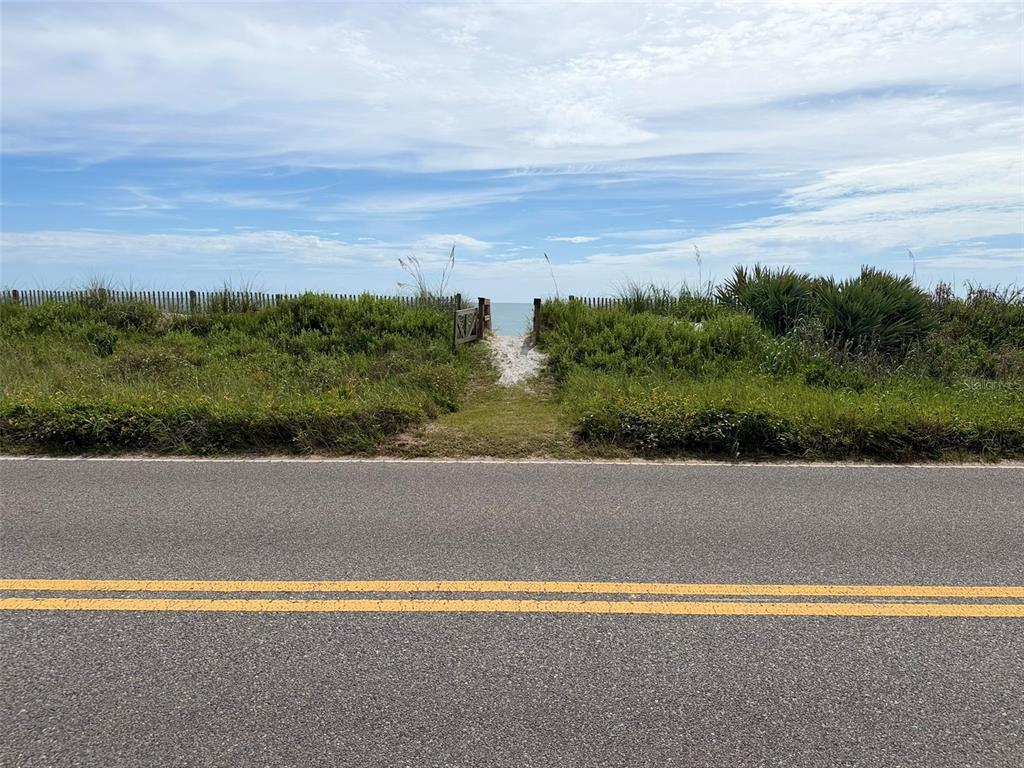 A paved road runs in front of a sandy path leading through dunes to the ocean — 00 S OCEAN SHORE BOULEVARD, FLAGLER BEACH, FL
