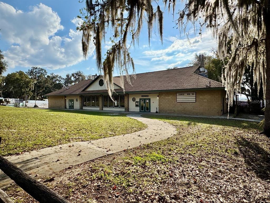 A single-story building with a tan brick facade and a walkway leading to the entrance — 25232 NE 143RD STREET UNIT 178, SALT SPRINGS, FL