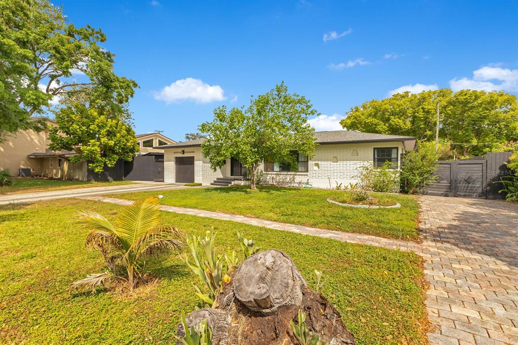 A single-story white brick house features a paved driveway, a front lawn, and mature trees — 344 STARLING ROAD, WINTER PARK, FL
