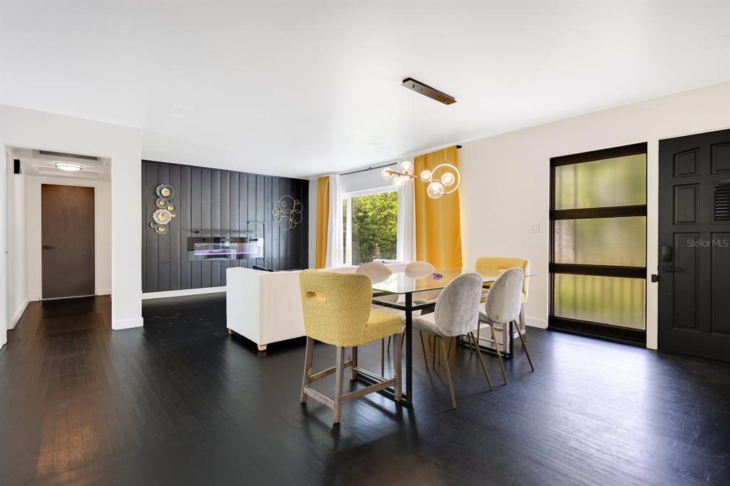 A dining area with a glass table, mixed chairs, and a black accent wall — 344 STARLING ROAD, WINTER PARK, FL