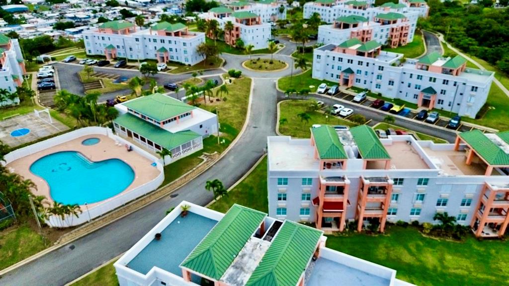 An aerial view shows a residential complex with apartment buildings, a swimming pool, and parking — Cond. La Loma B-104 UNIT 104, FAJARDO, PR