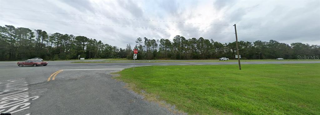 A view of a grassy roadside lot with a stop sign and a paved intersection — HIGHWAY 20, YOUNGSTOWN, FL