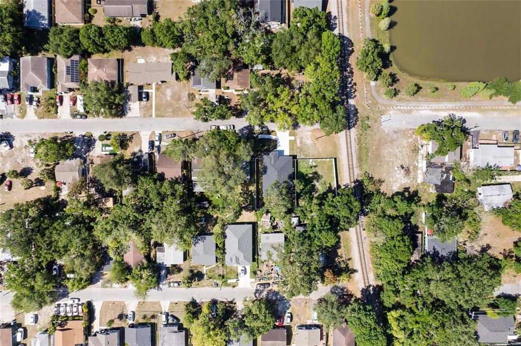 This aerial view shows a residential neighborhood with houses, trees, and a railroad track — 2619 E PALIFOX STREET, TAMPA, FL