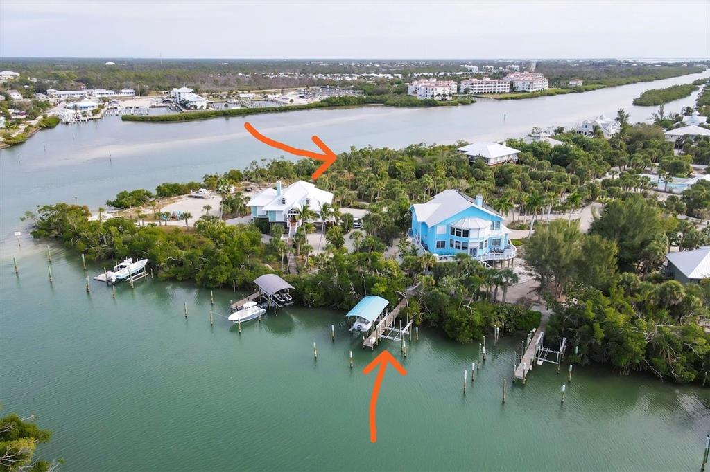 An aerial view shows two waterfront houses on a wooded lot with private boat docks — 6 POINTE WAY, PLACIDA, FL