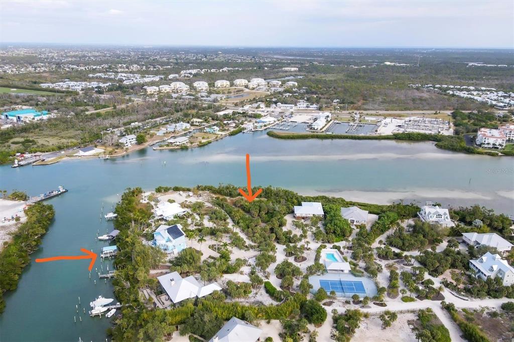 An aerial view shows waterfront homes, a tennis court, and a boat dock on a peninsula — 6 POINTE WAY, PLACIDA, FL