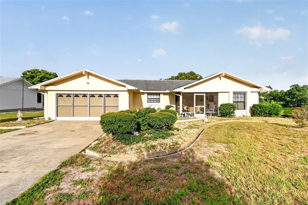 A single-story house with a garage, a screened-in porch, and a landscaped front yard — 7465 GALLOWAY ROAD, WEEKI WACHEE, FL