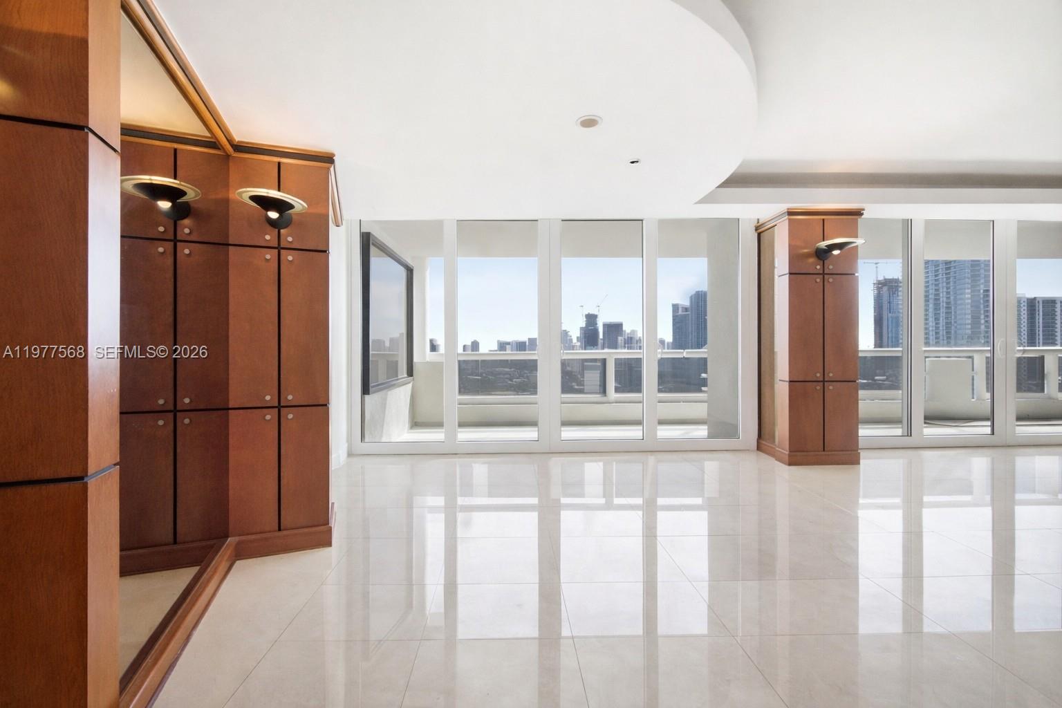 A bright room with polished tile floors, wooden cabinetry, and floor-to-ceiling windows overlooking a city — 1717 N Bayshore Dr # 3354, Miami FL 33132, MIAMI, FL