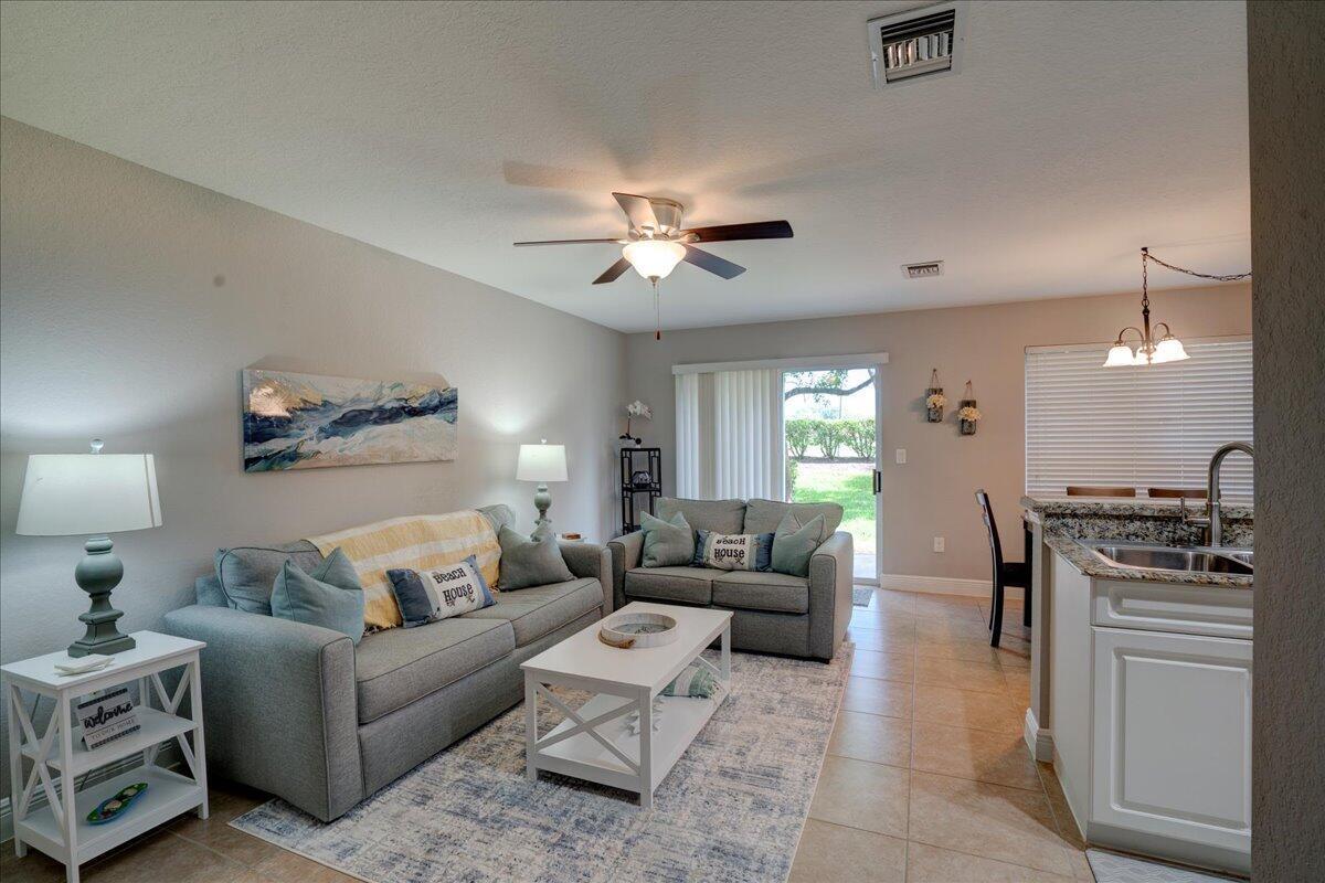 A living room features a gray sofa, a white coffee table, and an adjacent kitchen — 6633 Old Farm Trail, Boynton Beach FL 33437, BOYNTON BEACH, FL