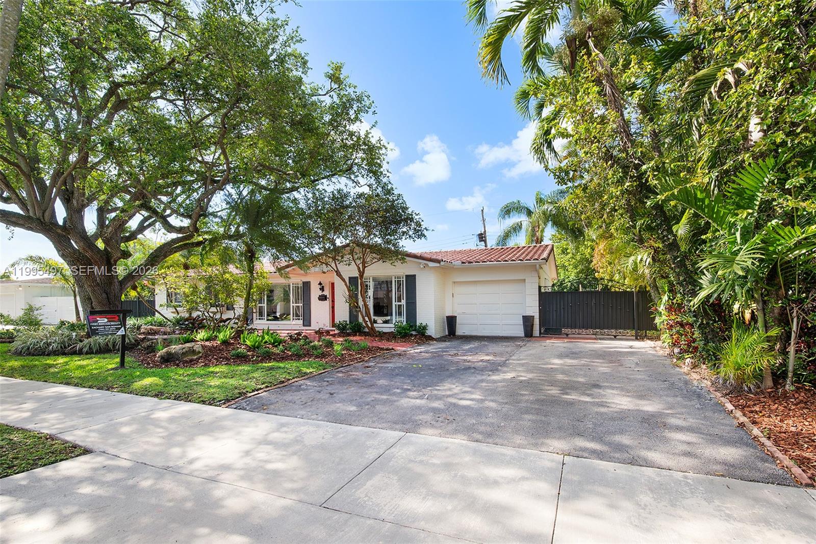 A single-story house with a white brick exterior, a tiled roof, and a paved driveway — 9370 SW 82nd St, Miami FL 33173, MIAMI, FL