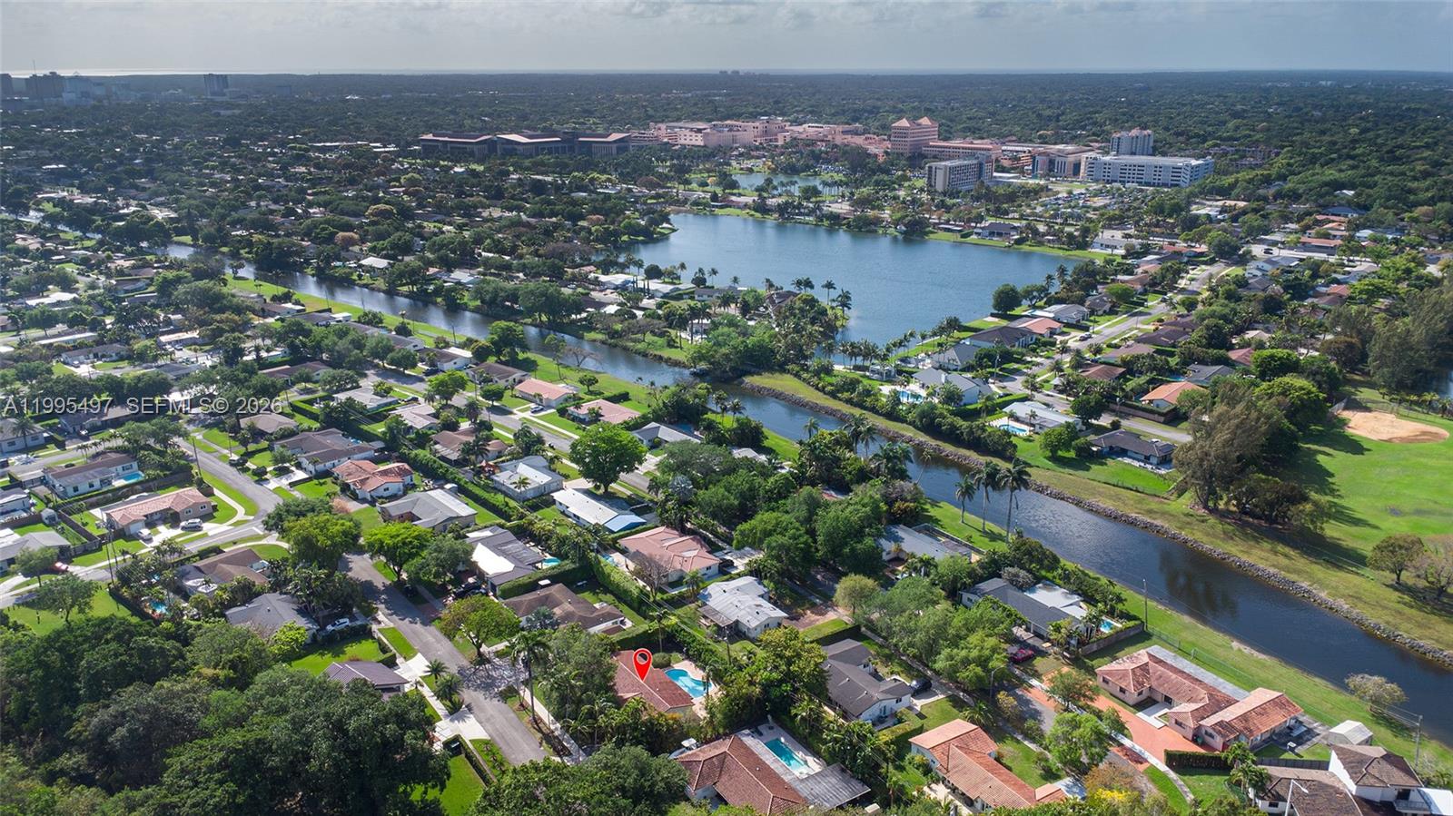 An aerial view shows a residential neighborhood with a canal, a lake, and a marked house — 9370 SW 82nd St, Miami FL 33173, MIAMI, FL