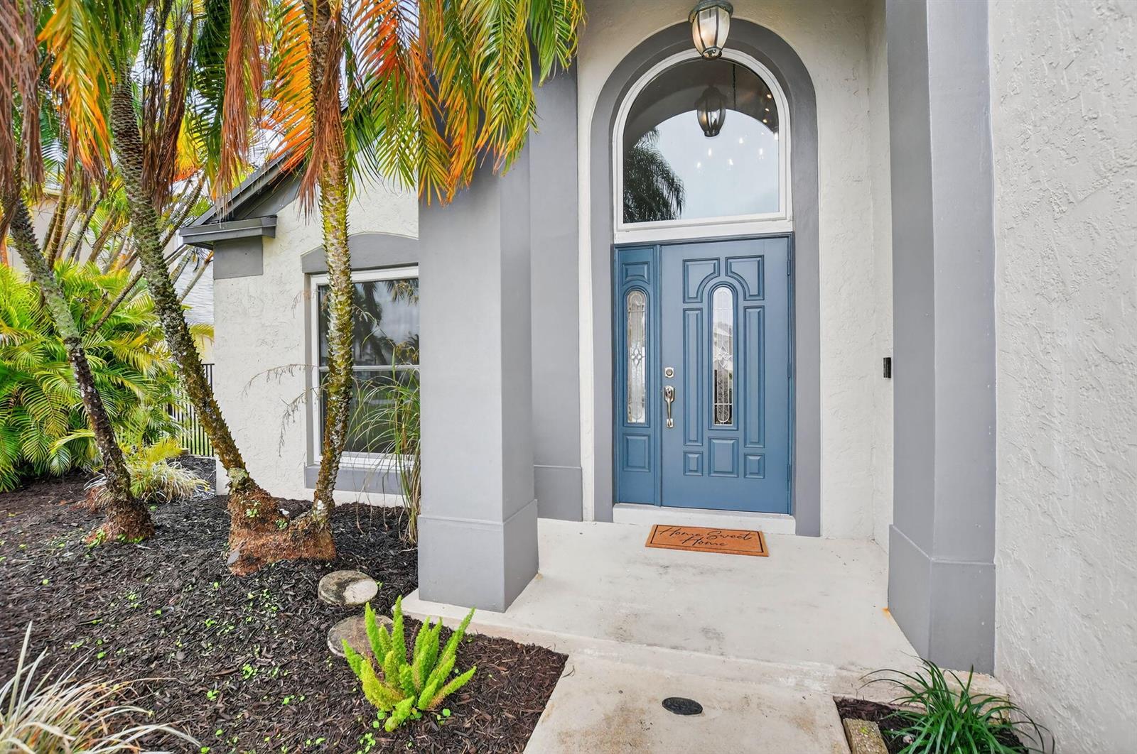 A blue front door with a glass transom window sits under an arched entryway — 22608 Middletown Drive, Boca Raton FL 33428, BOCA RATON, FL