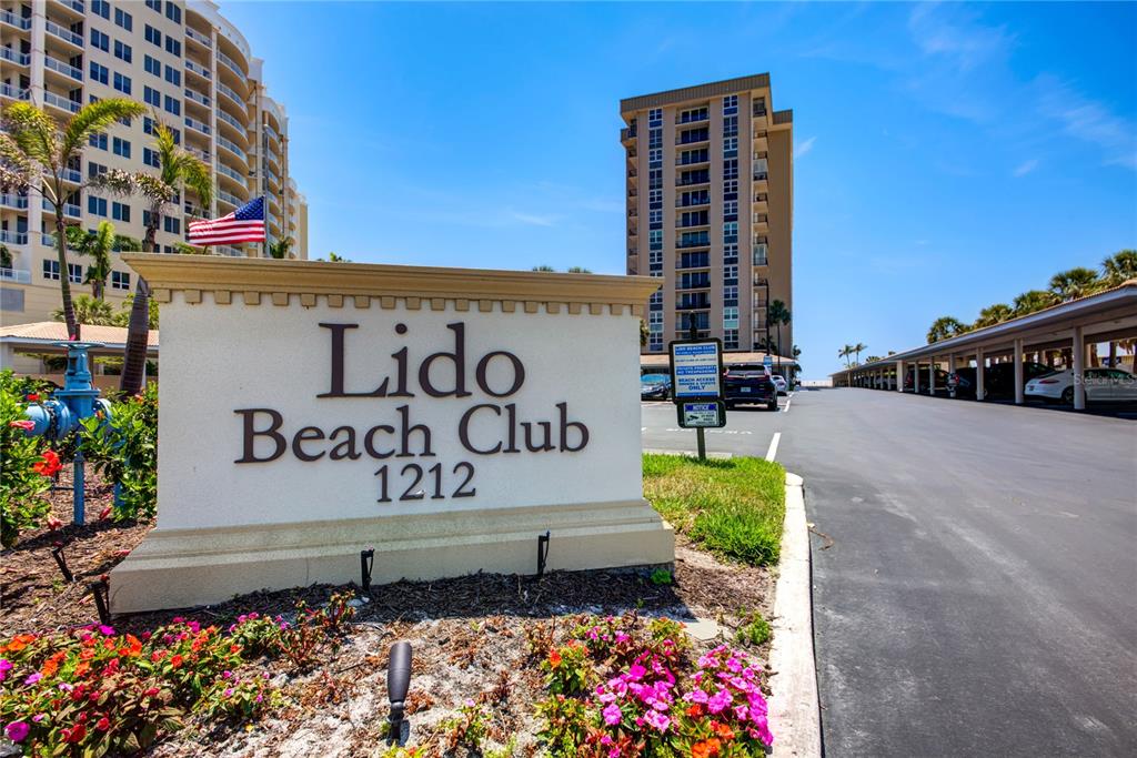 A sign for Lido Beach Club stands in front of a multi-story residential building — 1212 BENJAMIN FRANKLIN DRIVE UNIT 504, SARASOTA, FL