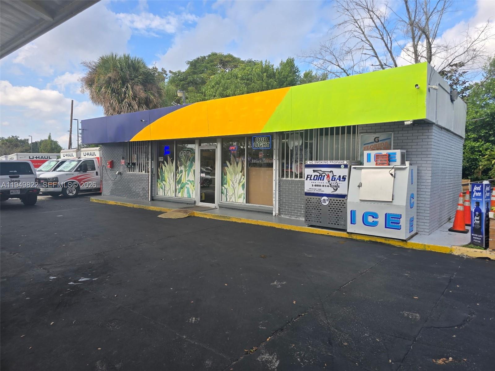 A small commercial building with a colorful awning, brick facade, and an outdoor ice machine — Confidential, Orlando FL 32806, ORLANDO, FL