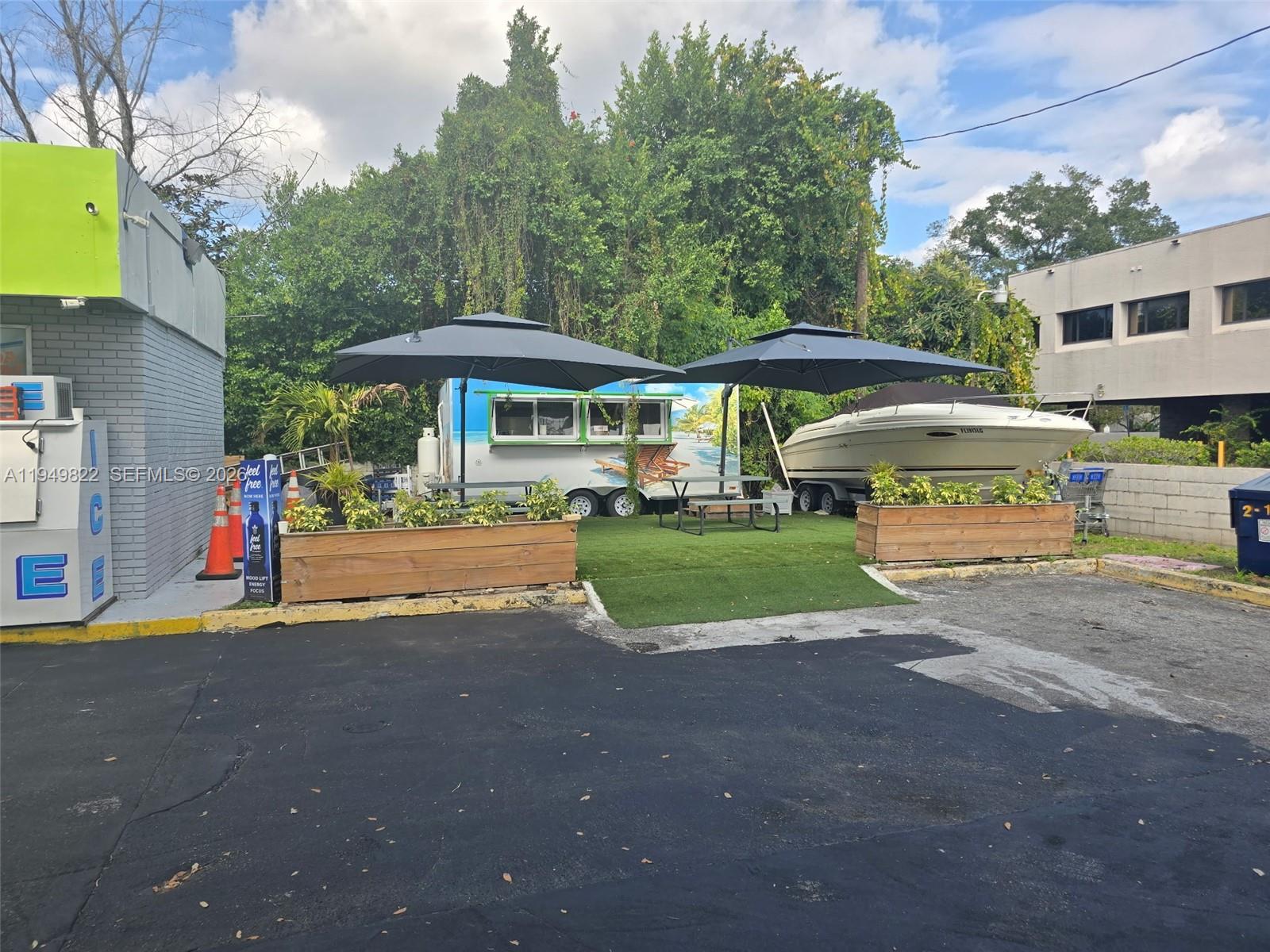 A food trailer and a boat are parked on a grassy lot with outdoor umbrellas — Confidential, Orlando FL 32806, ORLANDO, FL