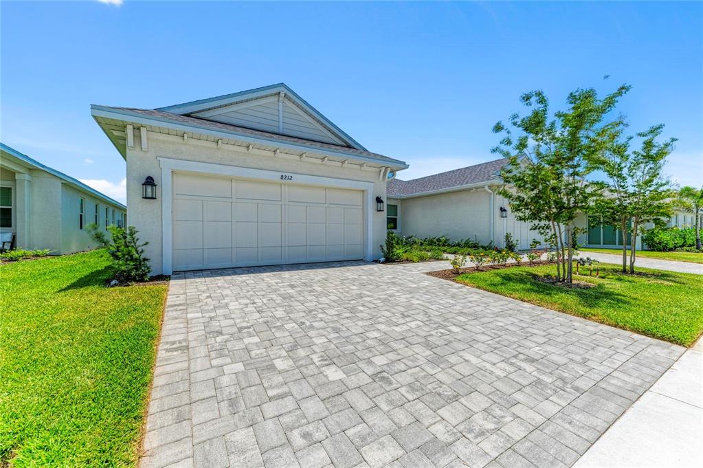 A single-story house features a paved driveway, a two-car garage, and a landscaped front lawn — 8212 CALLAHAN AVENUE, BRADENTON, FL