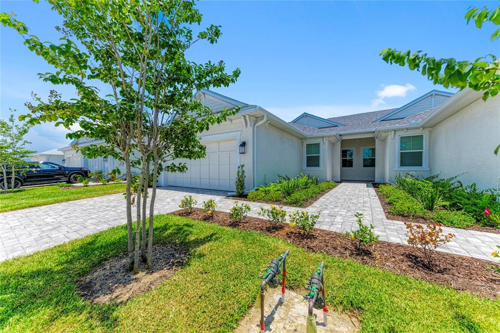 A single-story house exterior with a paved driveway, walkway, and a small tree in front — 8212 CALLAHAN AVENUE, BRADENTON, FL