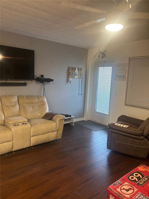 A living room features a light-colored reclining sofa, a dark armchair, and wood-look flooring — 133 BERKSHIRE UNIT 133, WEST PALM BEACH, FL