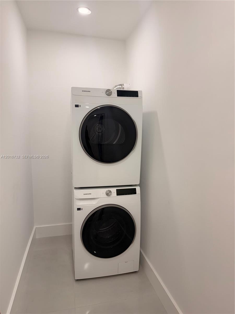 A stacked Samsung washer and dryer unit are installed in a small, white laundry closet — 6070 W 19th Ave # 315, Hialeah FL 33012, HIALEAH, FL